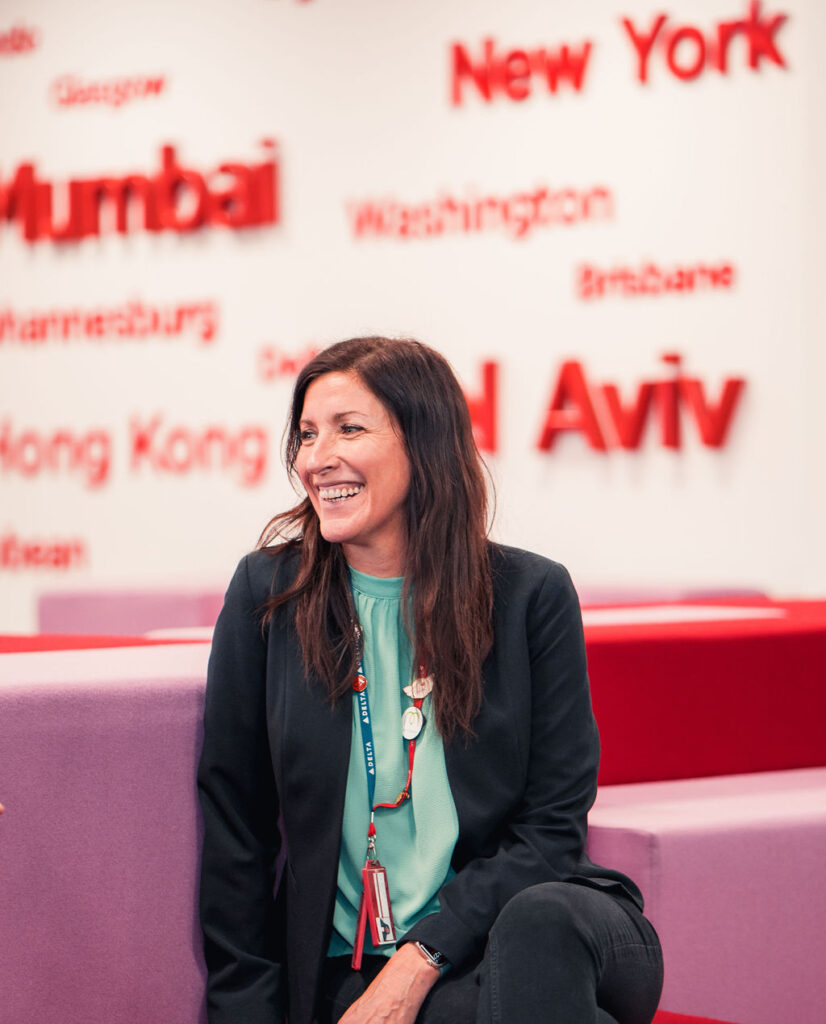 Virgin Atlantic employee sitting on a couch and smiling