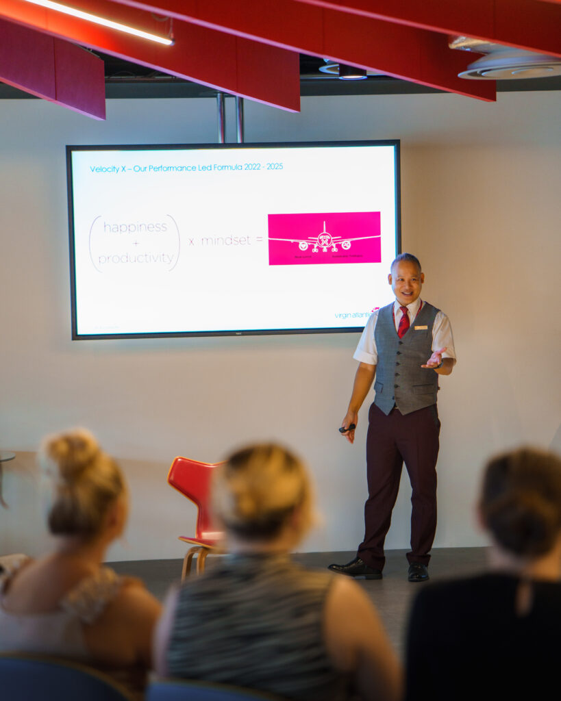 A man delivers a presentation on Virgin Atlantic to a captivated audience